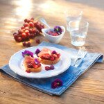 Vorspeise: Crostini mit Traubenchutney, Schinken und blauen Blüten