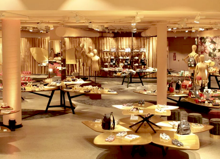 Goldfarbene Warenträger in Blütenform präsentieren Taschen, Schuhe und vieles mehr